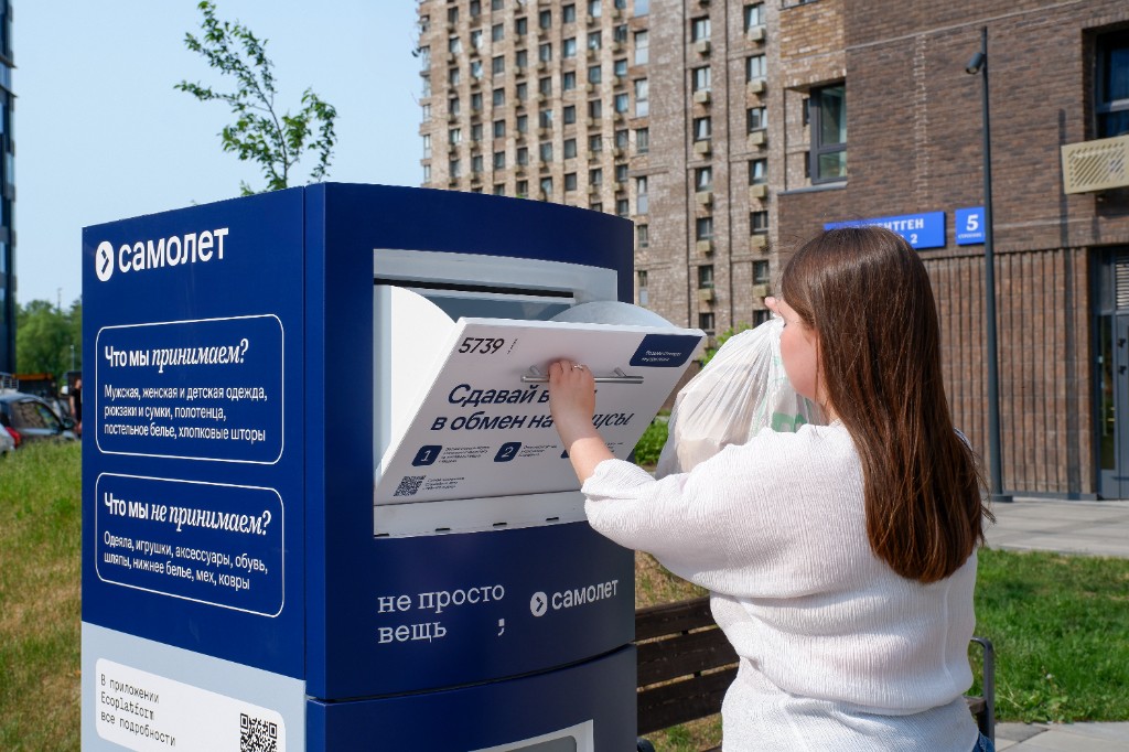 Опускание пакета с вещами в открытый экобокс